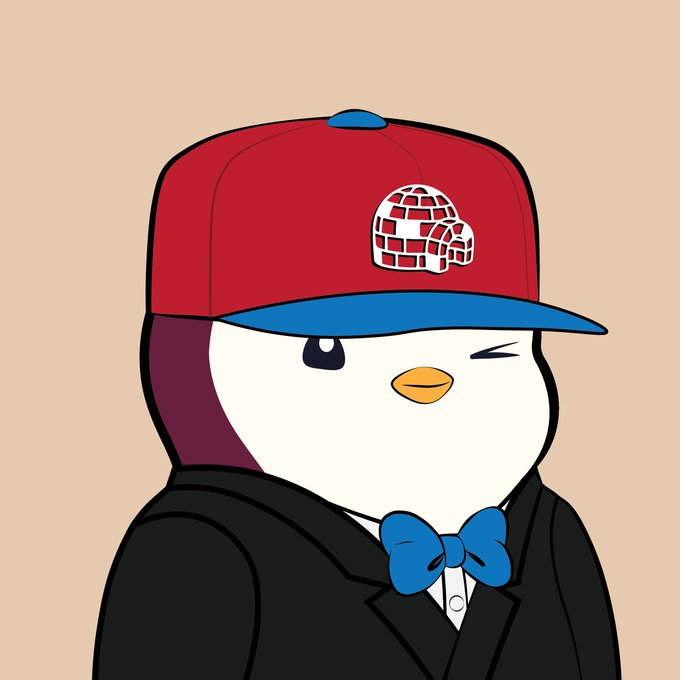 A cartoon penguin mascot wearing a red and blue baseball cap with an igloo logo, winking and dressed in a black suit with a blue bow tie against a beige background.