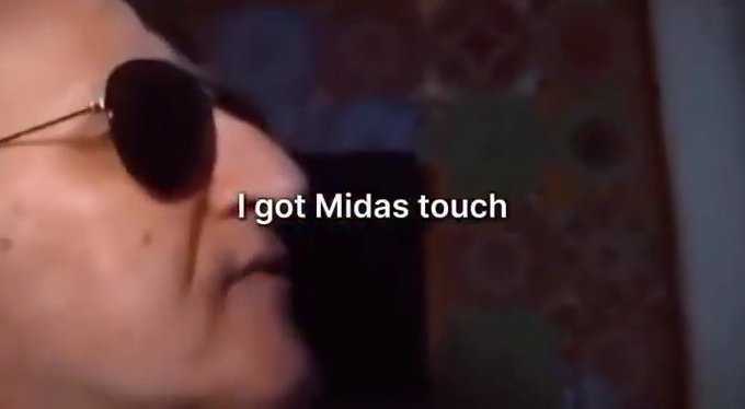 A close-up of a person wearing dark sunglasses with the text 'I got Midas touch' displayed on screen.