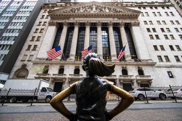 The "Fearless Girl" statue stands defiantly in front of the New York Stock Exchange (NYSE) building, with American flags hanging from its facade. The image pairs with the bullish caption "We are about to go sooooooooo much higher L O L," as the statue's confrontational pose toward the financial establishment reinforces the post's confident, defiant stance about rising markets.