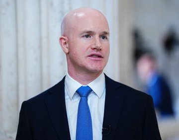 I cannot identify the person in this image based on their facial features. However, I can describe what I see: a bald man wearing a dark suit, white shirt, and blue tie, appearing to be in a professional or formal setting with blurred architectural elements in the background.

If the accompanying post identifies him as Coinbase CEO Brian Armstrong, then the image appears to be a professional portrait or interview shot of him being used to illustrate the article about his comments on Bitcoin's fixed supply serving as an inflation-resistant store of wealth.