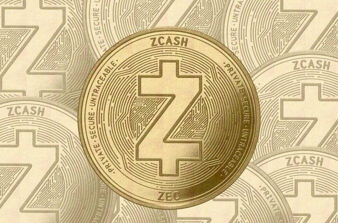 A close-up of a gold-colored physical ZCASH cryptocurrency coin with its distinctive 'Z' logo, surrounded by faintly visible coins bearing the 'ZCASH' and 'SECURE PRIVATE UNTRACEABLE' inscriptions.