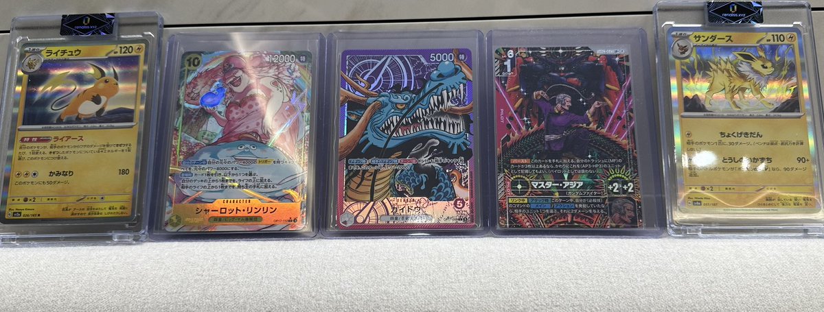 Five Japanese Pokémon trading cards displayed in protective top loaders, featuring Raichu, Sharpedo ex, a Blue Dragon card (5000 power), a character/film card (Master Frieza style), and Jolteon.