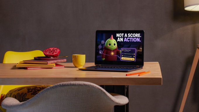 A modern home study setup with a tablet displaying "NOT A SCORE. AN ACTION." with a green cartoon character on the screen, placed on a wooden desk alongside a yellow mug, notebooks, a pomegranate, and an orange chair.