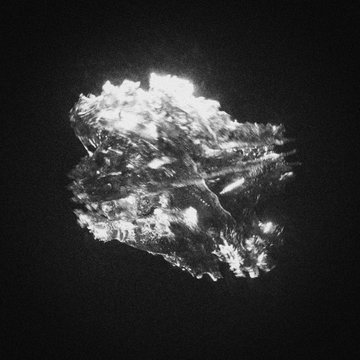 A high-contrast black-and-white close-up image of a rough diamond or crystal reflecting light against a dark background.