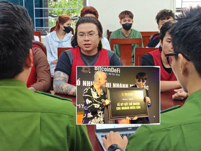 A group of people wearing masks sit around a table with laptops; an inset image shows two men holding a plaque reading 'BitcoinDeFi - LỄ KÝ KẾT HỢP ĐỒNG CHI NHÁNH MIỀN BẮC'.