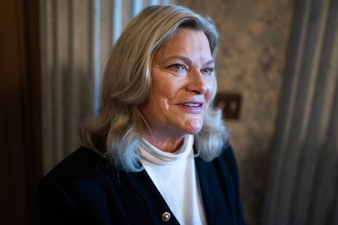 Senator Cynthia Lummis, smiling and dressed in a dark blazer over a white turtleneck, appears in a softly lit interior setting, visually representing the post's announcement about her confirming the updated CLARITY Act is ready for release with ongoing negotiations on its provisions.