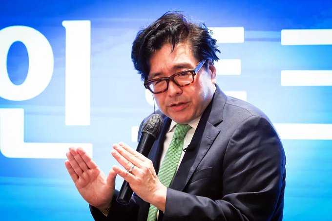 Tom Lee, co-founder of Fundstrat and chairman of BitMine Immersion Technologies, speaks into a microphone in front of a large blue presentation backdrop. His comments relate to BitMine’s accumulation of nearly 5.85 million ETH, approaching—but not yet reaching—5% of the total supply.
