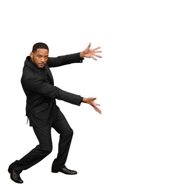 A man in a black suit strikes a martial arts-inspired pose against a white background, similar to Will Smith's iconic stance.