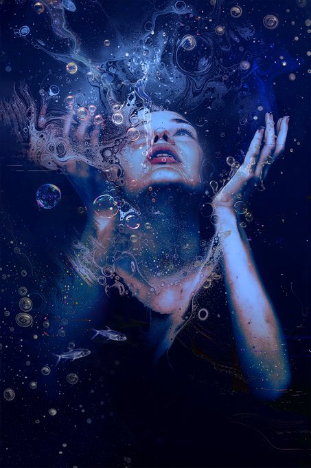 A woman floats submerged in deep blue water, her face turned upward and surrounded by bubbles as she stretches her arms toward the light above, evoking the feeling of trying to break through to the surface. Small fish and swirling currents drift around her, enhancing the sense of being suspended in a vast, otherworldly ocean—perfectly capturing the title "In the Arms of the Ocean" and the post's sentiment of longing and transcendence.