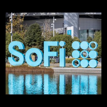 The image features a large blue sign that reads "Sofi" with circles around it, possibly representing a company or organization named "SoFi". The sign is located near a body of water, such as a lake or pond, which adds an interesting visual element to the scene. In the background, there are trees and buildings, indicating that this location might be in a city or urban area.

The image also contains text related to cryptocurrency, specifically mentioning "SoFi" has given access to its own crypto stablecoin for 15,000,000 users who are bullish for #CryptoXrp holders". This suggests that the company is actively promoting and investing in digital assets like Bitcoin and other cryptocurrencies.