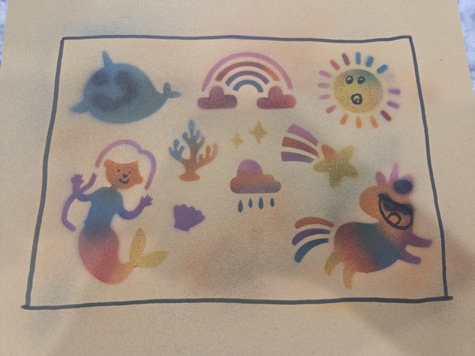 A colorful spray paint stencil artwork featuring whimsical characters like a rainbow, sun, whale, coral, cloud with rain, shooting star, and mermaids on a tan background, with the sun character in the upper right resembling a Veefriends Stunned Sun design.