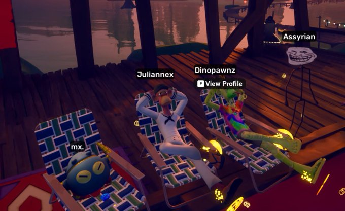 The image shows three people sitting on chairs with their heads resting on them. One person has a blue and white striped chair, another has a green and white striped chair, and the third has a brown and white striped chair. The background features a wooden deck overlooking water, creating an outdoor setting for relaxation. A post about a video game is visible in the image, with the caption "A koda, two apes, and a. $TROLL!!!".