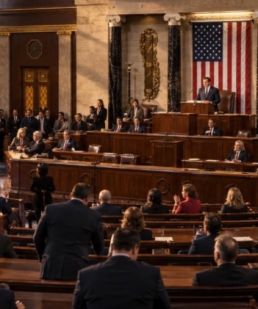 A man speaking at a podium inside a legislative chamber resembling the U.S. Capitol, with members of Congress seated before him.