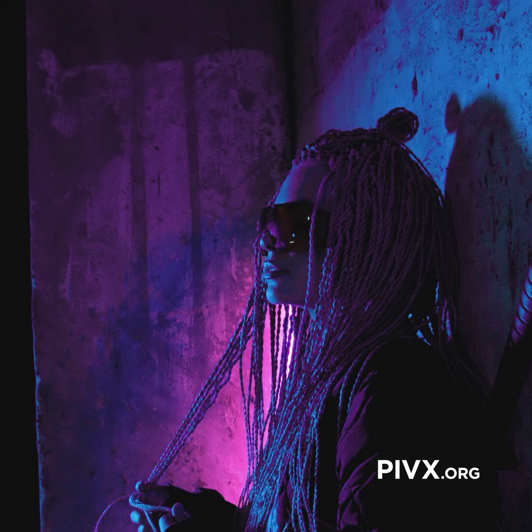 The image features a woman with long braids wearing sunglasses and holding a cigarette. The background of the photo has purple and blue hues, giving an artistic touch to the scene. The caption below the image reads "What are your criticisms of cryptocurrency in 2026? Don'T be shy, not every technology is perfect, what do you think the industry could improve on?". This suggests that the woman might have some concerns or opinions about cryptocurrency and wants to share them with others through this image.