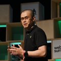 A man in a black shirt with a headset around his neck speaking on stage at what appears to be a Web Summit event.