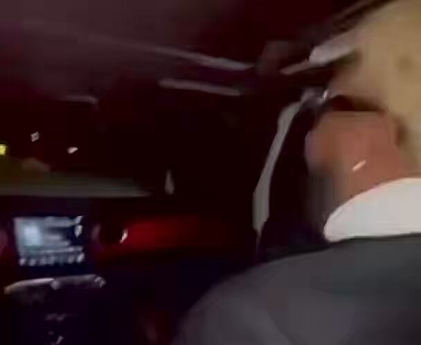 The focus of this image should be on a man driving a car, which appears blurry or out of focus, possibly due to movement during the shot. The background features an orange glow, likely from the screen of the car's dashboard, which also appears slightly blurred. In addition, there is some text that reads "That feeling when $XRP is setting up for $8.42", which could be related to the car or cryptocurrency market in general. However, this specific content might not be directly applicable to the main subject of the image - a man driving a car on a road at night.