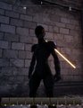 A dark silhouetted figure holding a glowing yellow lightsaber-like object stands against a brick wall background.