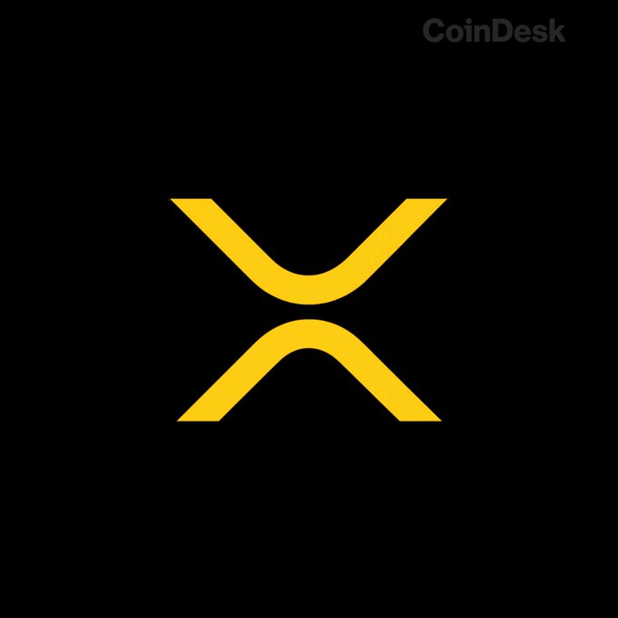 The image displays the distinctive yellow XRP logo centered on a black background, with a "CoinDesk" watermark in the top right corner. The branding visually reinforces the accompanying post's reference to $XRP whale activity and price projections.