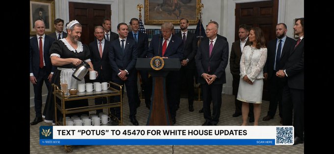The image shows a White House event featuring President Trump at a podium, flanked by a maid serving coffee from a cart and various officials including Sergey (likely referring to a Russian representative) and Brad (likely referring to an attendee). The caption "TEXT 'POTUS' TO 45470 FOR WHITE HOUSE UPDATES" appears at the bottom of the screen. The accompanying post humorously comments on the unlikely pairing of a maid serving coffee alongside high-profile figures in this formal setting.