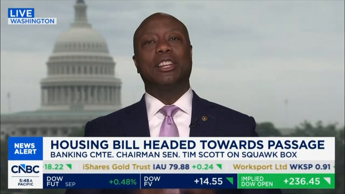 The image shows a news segment featuring a man dressed in a suit, talking about housing bill headed towards passage. The news anchor is reporting that the Senate Banking Chair has confirmed that the digital dollar will be law within weeks. This information is relevant to the discussion on housing and the economy as it may impact how people pay for their homes or conduct financial transactions.