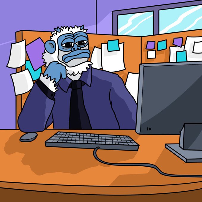 A cartoon illustration of a tired-looking blue gorilla in a shirt and tie sitting at a desk with a computer monitor and keyboard, with colorful sticky notes on the cubicle wall behind him.
