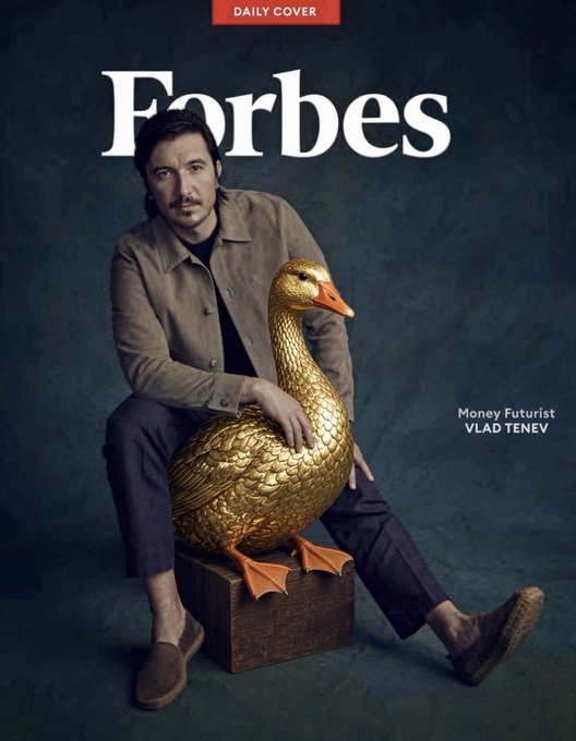 A Forbes 'Daily Cover' featuring 'Money Futurist VLAD TENEV' seated on a wooden stool with a large golden goose statue, set against a dark teal backdrop.