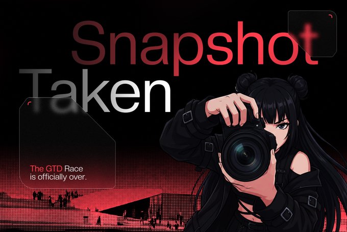 An anime-style illustration of a girl with black hair holding a camera, with the text 'Snapshot Taken' and 'The GTD Race is officially over.' displayed on a red-toned background.