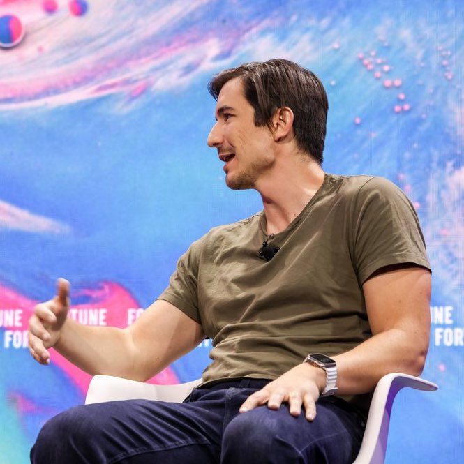 Robinhood CEO Vlad Tenev speaks at a conference, with a blurred "CL" logo visible in the background. The accompanying post quotes him discussing how tokenization's real-time settlement could have prevented trading halts like those seen during the 2021 GameStop squeeze.