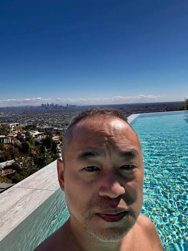 Machi (@machibigbrother) takes a selfie in an infinity pool overlooking the Los Angeles skyline, projecting a relaxed, wealthy lifestyle that contrasts with the post's report of his $16M loss on $FRIEND tokens.