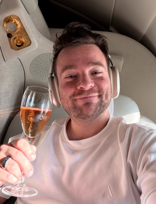 Image 2: A smiling man wearing headphones holds a glass of sparkling wine in what appears to be an airplane or luxury transport cabin with leather seats.