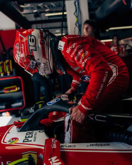 Ferrari driver #16 leans into his cockpit during a tense pit stop at the Spanish Grand Prix in Madrid, decked out in full red race suit with BingX and Santander branding visible, capturing the razor-thin margins that defined qualifying.