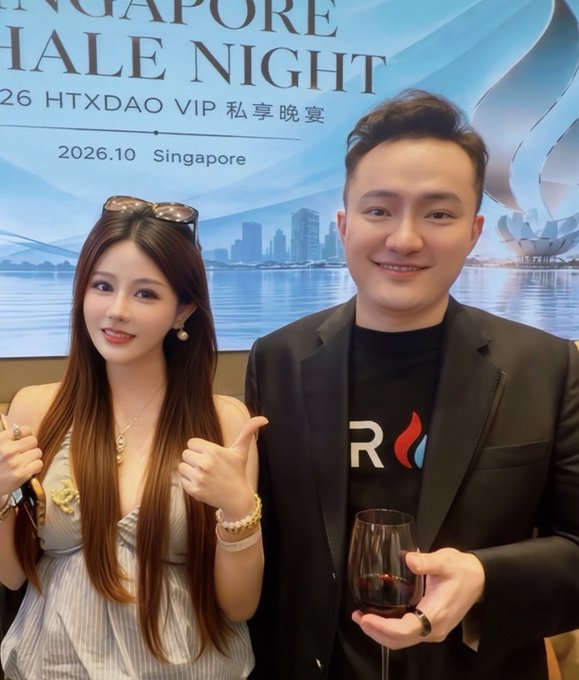 A man and woman pose together at the "SINGAPORE WHALE NIGHT" event hosted by "HTXDAO VIP" in Singapore on 2026.10, with the man holding a glass of red wine.