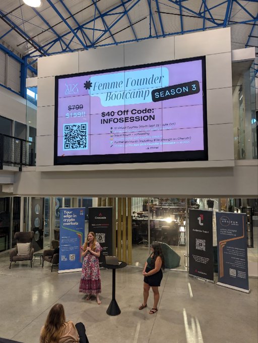 A presentation in a modern atrium features a woman standing before a large screen displaying "Femme Founder Bootcamp Season 3," offering a "$40 Off Code: INFOSESSION" with a QR code and pricing details ($799, struck-through $1,199).