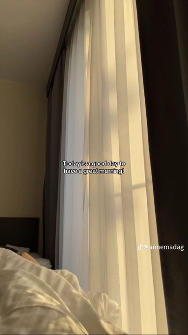A cozy bedroom scene with sunlight streaming through sheer curtains, overlaid with the text 'Today is a good day to have a great morning!' and the TikTok handle @annemadag.