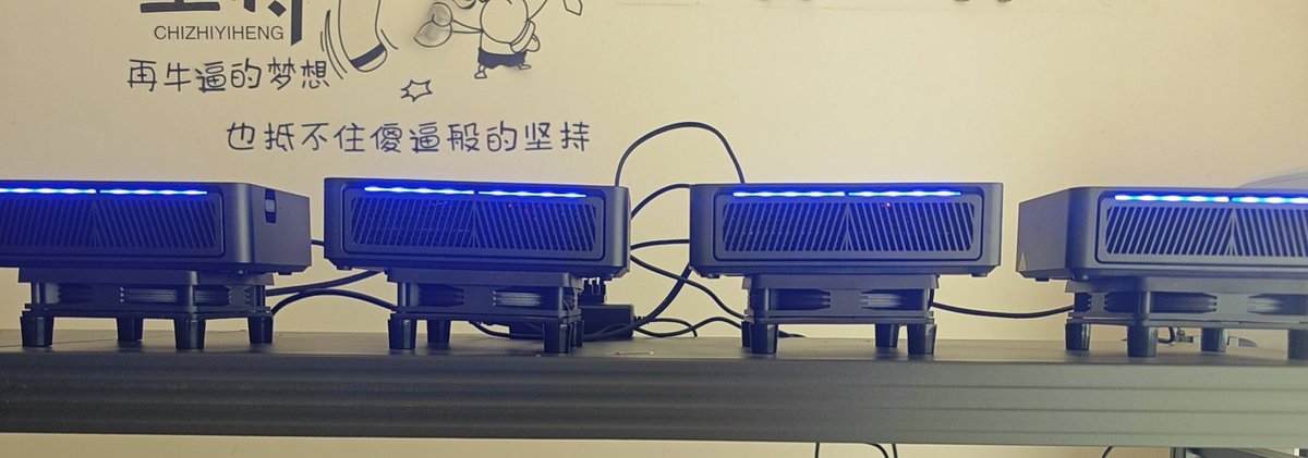 Four electronic devices with blue LED lights and ventilation grilles sit on a shelf, with Chinese text and 'CHIZHIYIHENG' branding visible on the wall behind them.