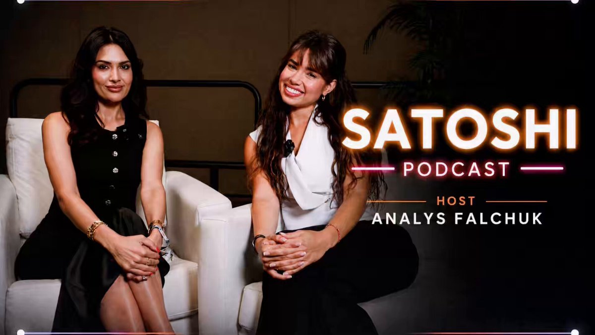 The image features two women sitting next to each other on chairs, smiling at the camera. They are positioned behind a white banner that displays the title "Satoshi Podcast Episode 1" along with the names of the hosts, Nikita and Anlys Falchuk. The hosts appear to be discussing Bitcoin and its impact on their lives.