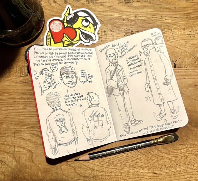 An open sketchbook on a wooden surface with pen-and-ink doodles and notes documenting a Vegas trip, including mentions of 'Vee Friends', a Danger Dave dinner, and a Beadles After Party, accompanied by a cartoon fish sticker and a Faber-Castell pencil.