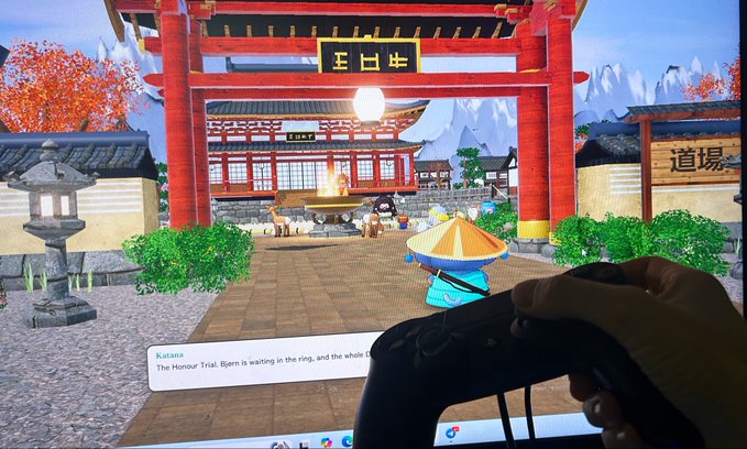 A first-person view of someone holding a video game controller, playing a virtual reality simulation set in a Japanese-style dojo with a torii gate and characters, with text mentioning 'Katana' and 'The Honour Trial'.