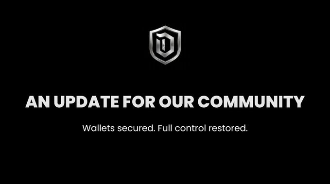 A black screen with a silver shield logo and text reading 'AN UPDATE FOR OUR COMMUNITY' followed by 'Wallets secured. Full control restored.'