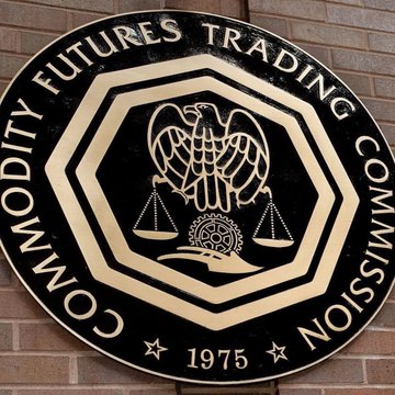 The image displays a black and gold seal of the Commodity Futures Trading Commission (CFTC), established in 1975, featuring an eagle, scales of justice, and a ship's wheel. The seal relates to the announcement by illustrating the regulatory body that just approved Coinbase Clearing LLC as a derivatives clearing organization.