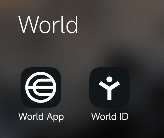 Two app icons labeled "World App" (featuring a globe-like "e" logo) and "World ID" (featuring a person-shaped "Y" logo) are displayed under the heading "World," illustrating the split of the original app into a separate wallet and identity verification application.