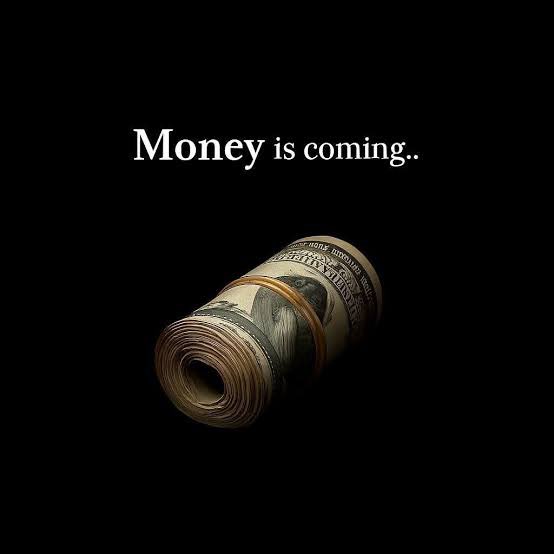 A rolled-up stack of U.S. hundred-dollar bills bound with a rubber band sits against a black background, accompanied by the text "Money is coming.." displayed above it.