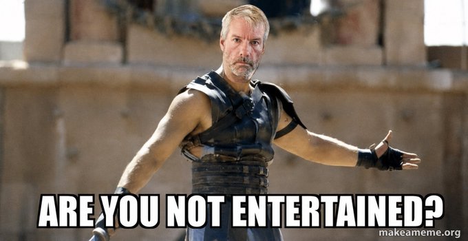 A graying, bearded warrior in gladiator armor stands defiantly in an arena with the bold caption "ARE YOU NOT ENTERTAINED?" The image humorously relates to the post by suggesting Michael Saylor is dramatically asking spectators to marvel at his recent financial turnaround from a massive $10 billion loss to a $3 billion profit in just 48 hours, much like a victorious gladiator addressing the crowd after a stunning reversal of fortune.