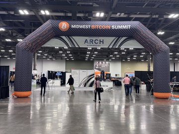 An inflatable archway at a convention center reads 'MIDWEST BITCOIN SUMMIT' with 'ARCH' branding displayed below it.