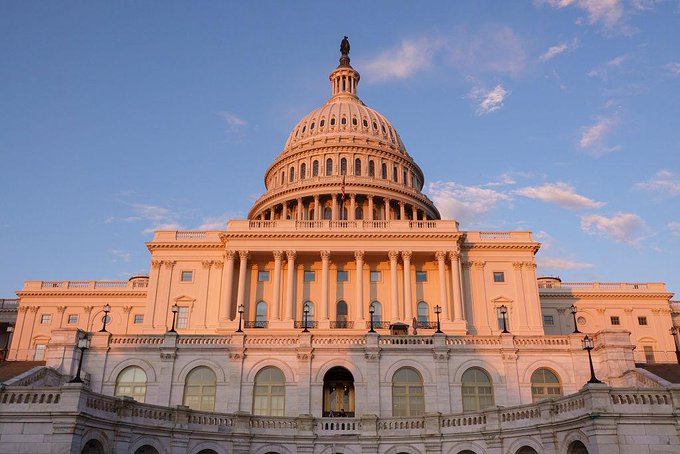 The United States Capitol building is shown at sunset, its white dome and classical columns glowing in warm golden light against a blue sky. The image ties into the post's call for citizens to reach out to Congress, as the Capitol is the seat of legislative action where citizens' voices can shape digital asset policy.
