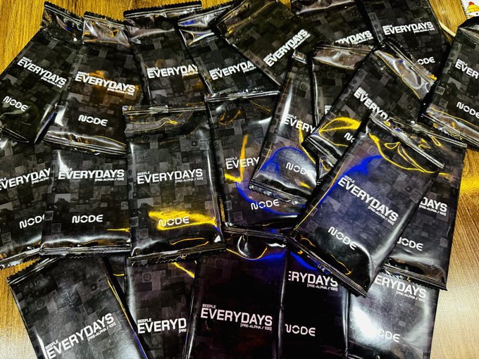 A pile of black "Everydays Pre-Alpha / Node" packets scattered on a wooden surface, fitting the cryptic "Probably Nothing." caption with its tech/startup packaging aesthetic.