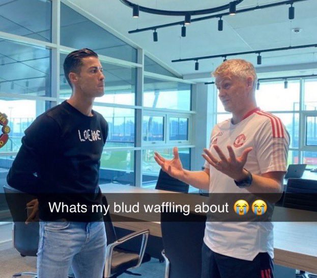 Two men in a modern office setting, with text overlay reading 'Whats my blud waffling about 😭😭'.