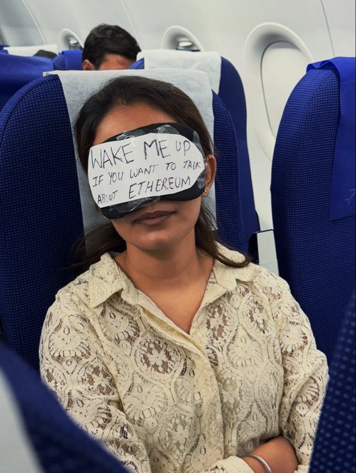 A woman on an airplane wears a sleep mask reading "WAKE ME UP IF YOU WANT TO TALK ABOUT ETHEREUM," humorously playing on the "Any takers?" caption by inviting only crypto enthusiasts to disturb her rest.