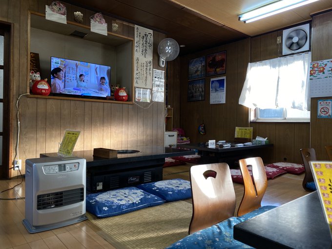 A traditional Japanese-style room with wooden walls, tatami mats, and a TV displaying a program, alongside decorative items like a daruma doll and calligraphy. The image appears unrelated to the accompanying post about cryptocurrency or $KAITO.