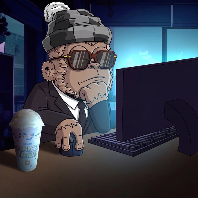 Cartoon illustration of a relaxed monkey wearing sunglasses and a beanie, sitting at a computer with a McDonald's McCafé birthday cup.